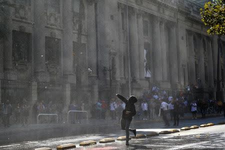 Un manifestante arroja una botella a la policía durante una protesta para demandar cambios al sistema de educación en Santiago de Chile. 11 de abril de 2017. REUTERS/Ivan Alvarado