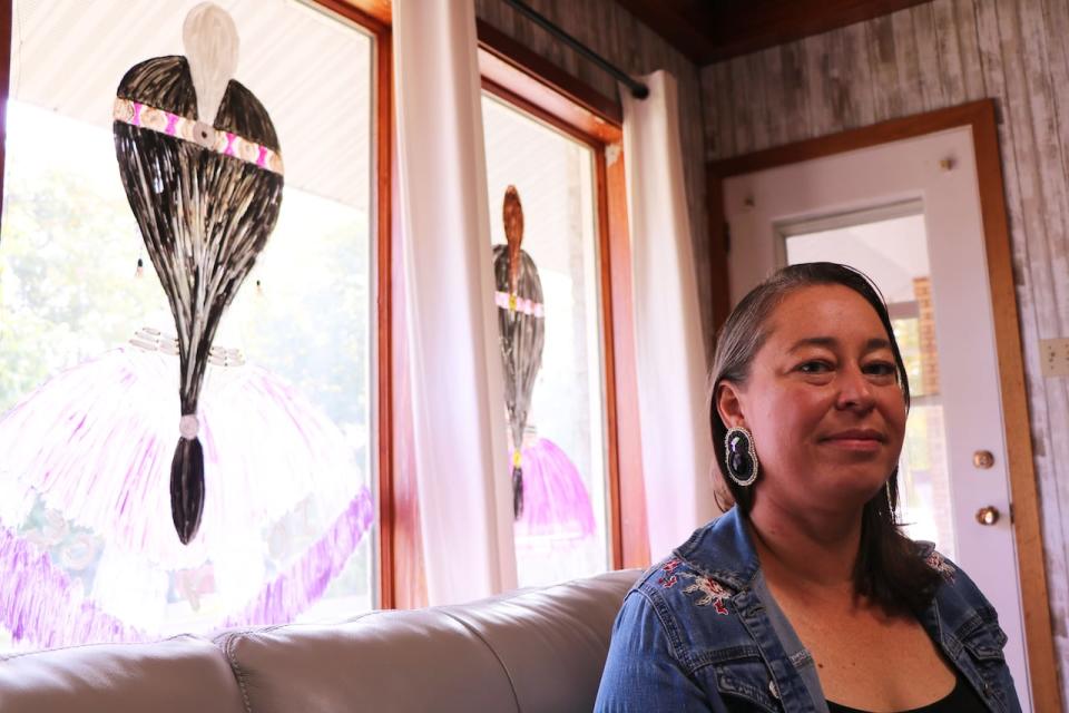 Jennifer Brazeau, the executive director of the Centre d'amitié autochtone de Lanaudière, sits by the centre's windows which were painted by a staff member in honour of Joyce Echaquan.