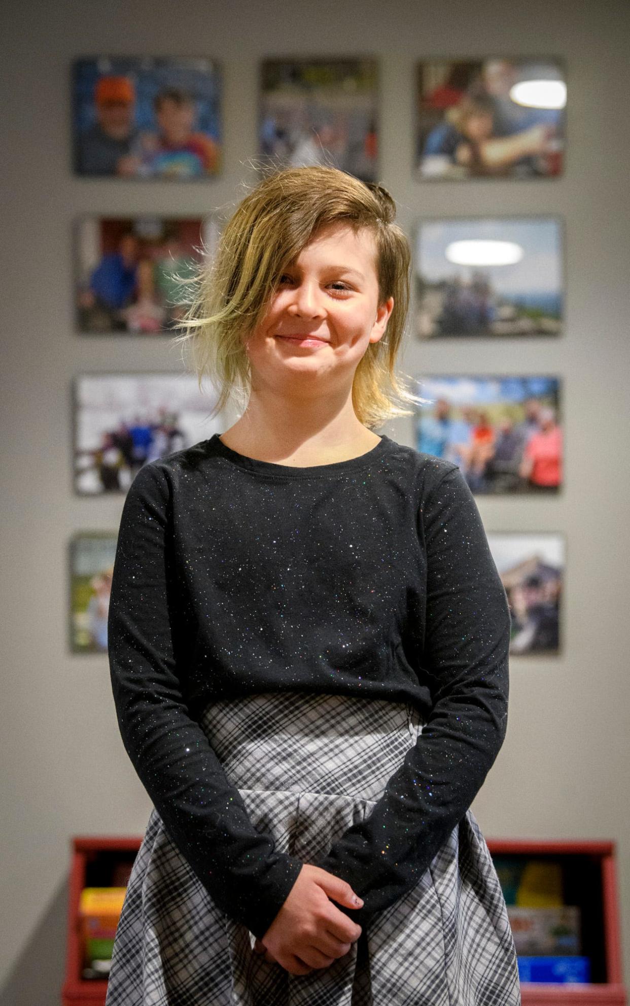 Kirin Clawson poses Wednesday in front of family pictures in her home.