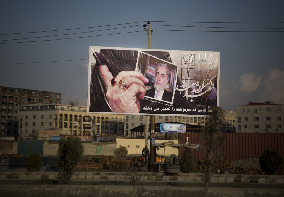 In this Monday, March 17, 2014 photo, a giant election poster of an Afghan woman showing with her ink finger that she voted and holding up a picture of presidential candidate Abdullah Abdullah in the center of Kabul, Afghanistan. Abdullah, who was a candidate in the heavily criticized 2009 elections, also participated in the violent 1990s civil war. He was a close ally of Ahmad Shah Massoud, the leader of the Northern Alliance that fought the Taliban and a powerful anti-Soviet commander. Massoud was killed by an al-Qaida suicide bomber two days before the Sept. 11, 2001 terror attacks in the United States. (AP Photo/Anja Niedringhaus)