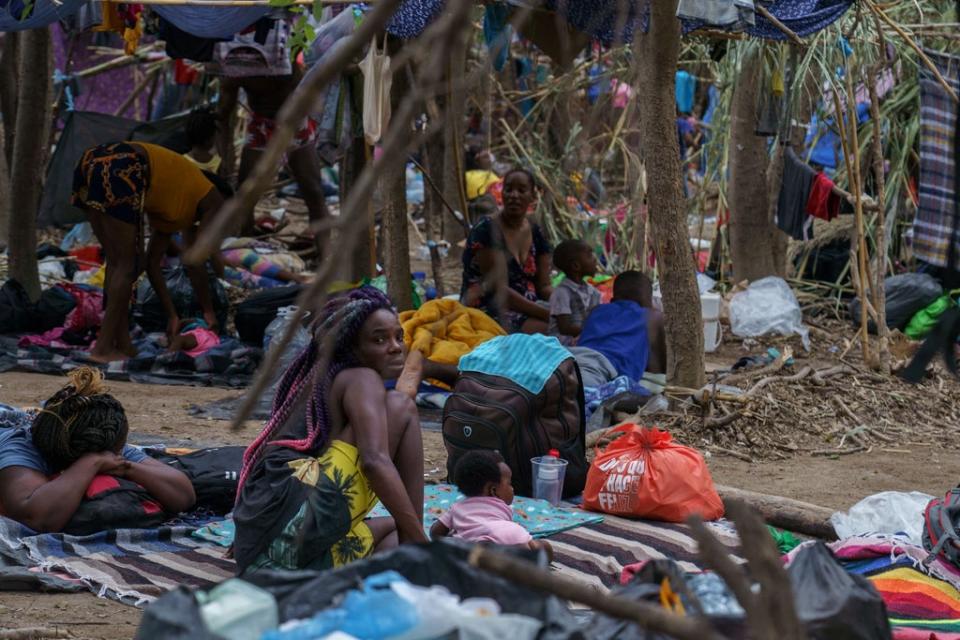 Haitian migrants are pictured in a makeshift encampment where more than 12,000 people hoping to enter the United States await under the international bridge in Del Rio, Texas on 21 September 2021 (AFP via Getty Images)