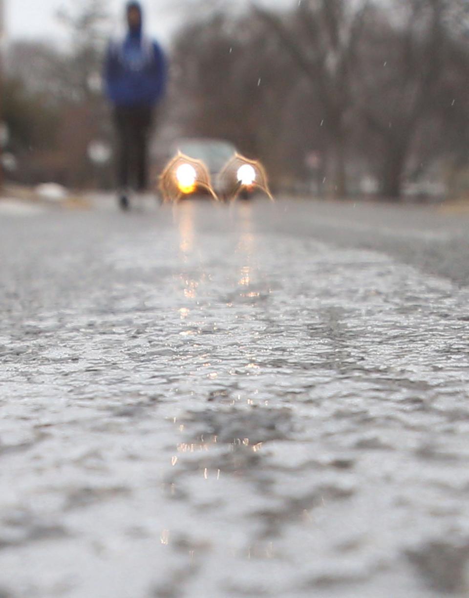 Ice reflects on 12th Street during frizzing rain on Wednesday, Feb. 22, 2023, in Ames, Iowa 