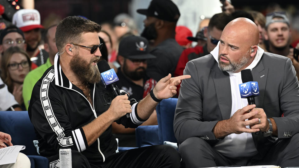 Football analysts Ryan Fitzpatrick, left, and Andrew Whitworth talk before an NFL football game Baltimore Ravens and the Tampa Bay Buccaneers Thursday, Oct. 27, 2022, in Tampa, Fla. (AP Photo/Jason Behnken)