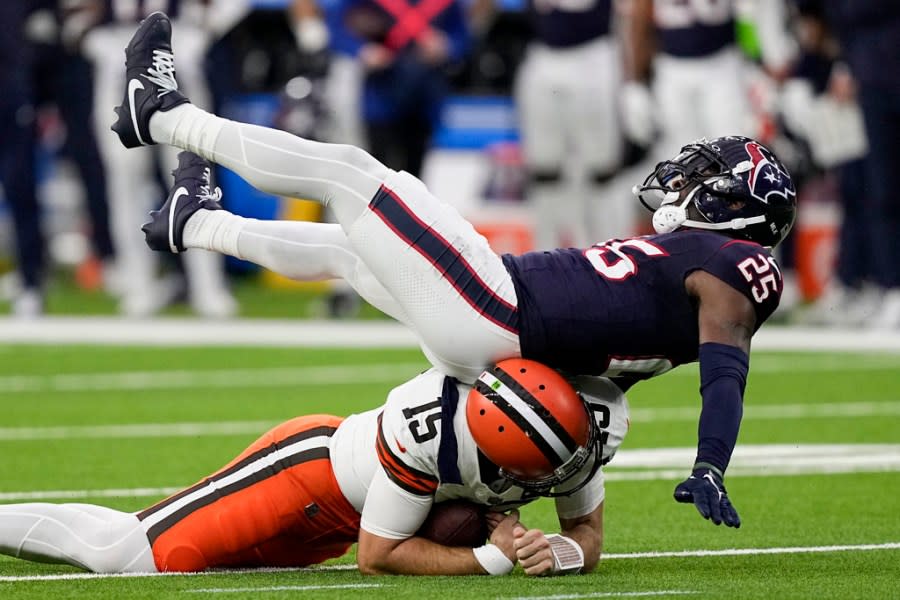 Cleveland Browns quarterback Joe Flacco is tackled by Houston Texans cornerback Desmond King II during the first half of an NFL wild-card playoff football game Saturday, Jan. 13, 2024, in Houston. (AP Photo/David J. Phillip)