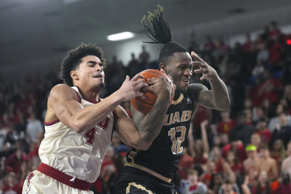 Florida Atlantic guard Bryan Greenlee (4) and UAB guard Tony Toney (12) go after a rebound during the first half of an NCAA college basketball game, Sunday, Jan. 14, 2024, in Boca Raton, Fla. (AP Photo/Marta Lavandier)