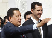 El presidente de Venezuela, Hugo Chávez, a la izq., saluda a periodistas junto al presidente sirio Bashar Assad, a la derecha, en el palacio presidencial de Damasco, Siria, el jueves 21 de octubre del 2010. (Foto AP/Hussein Malla)