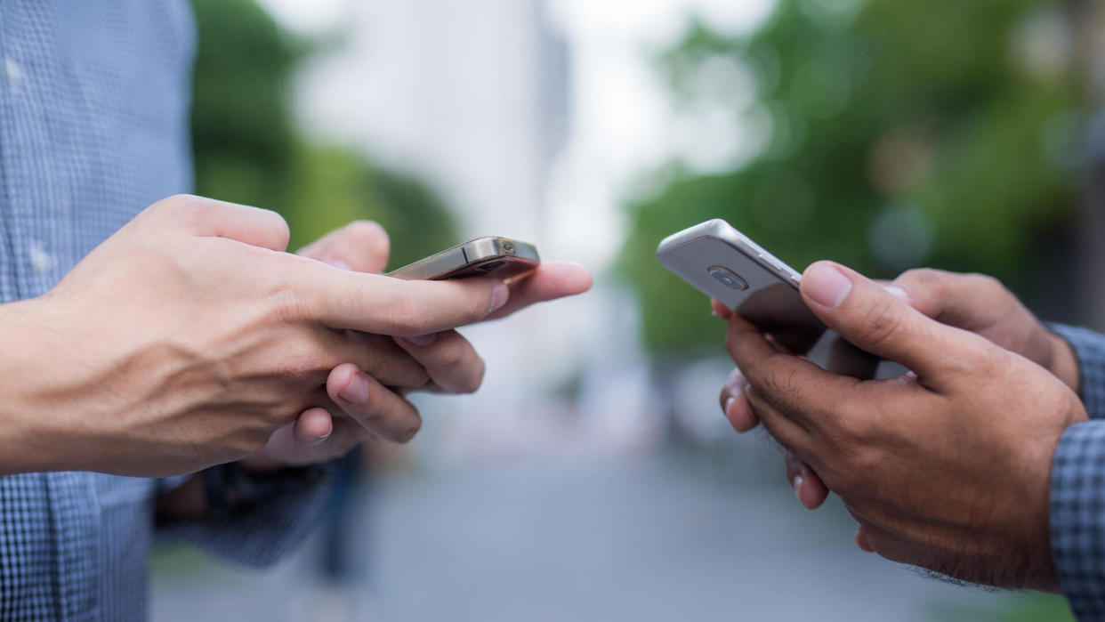 Two people holding smartphones