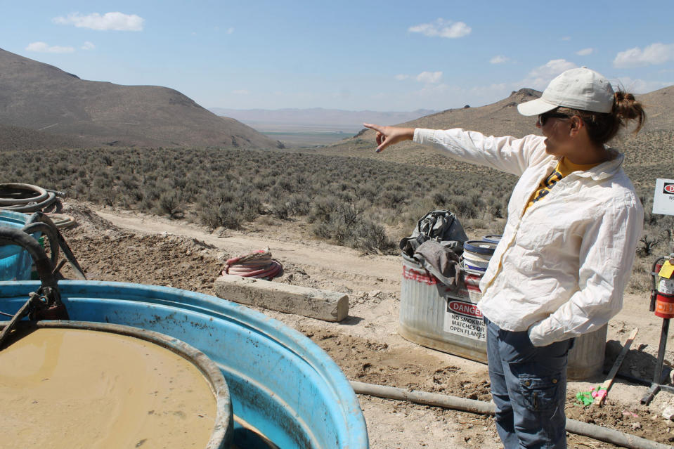 FILE - Melissa Boerst, a Lithium Nevada Corp. geologist, points to an area of future exploration from a drill site at the Thacker Pass Project in Humboldt County, Nev., Sept. 13, 2018. On Friday, Feb. 24, 2023, a federal judge sided again with the Biden administration and a Canadian-based mining company in a fight with environmentalists and tribal leaders trying to block a huge lithium mine in Nevada near the Oregon line. (Suzanne Featherston/The Daily Free Press via AP, File)