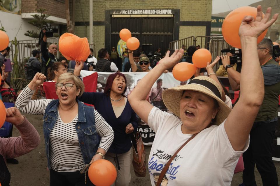 Supporters of jailed president Alberto Fujimori dance outside the prison where he is interned in the outskirts of Lima, Peru, Tuesday, Dec. 5, 2023. Peru's constitutional court ordered an immediate humanitarian release for the imprisoned former President who was serving a 25-year sentence in connection with the death squad slayings of 25 Peruvians in the 1990s. (AP Photo/Martin Mejia)