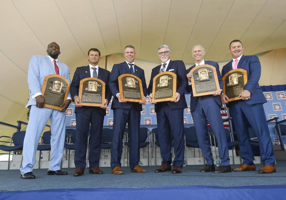 Baseball Hall of Famers from left, Vladimir Guerrero, Trevor Hoffman, Chipper Jones, Jack Morris, Alan Trammell, and Jim Thome, hold their plaques after an induction ceremony at the Clark Sports Center on Sunday, July 29, 2018, in Cooperstown, N.Y. (AP Photo/Hans Pennink)