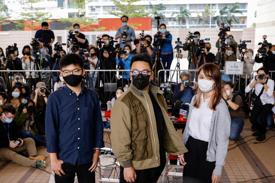 Pro-democracy activists Ivan Lam, Joshua Wong and Agnes Chow arrive at the West Kowloon Magistrates' Courts to face charges related to illegal assembly stemming from 2019, in Hong Kong, China November 23, 2020. / Credit: TYRONE SIU/REUTERS