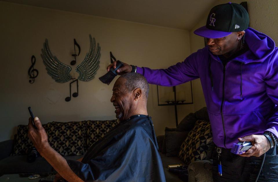 Derrick McAtee, an Indianapolis barber, trims the hair of Fred Norris inside Norris' home Tuesday, March 15, 2022, on the city's east side. McAtee began cutting his hair at home when Norris' mobility became an issue. "When he couldn't get down the steps, I'm coming out here," McAtee said. "I'm not losing him as a customer." The two have built a close friendship. Norris typically never talks about his time in Vietnam as a Marine but shares stories with McAtee. During his hair trim, Norris calls a friend who of which he served with in the 3rd Battalion, 3rd Marines, Phil Styles. Besides Styles, Norris keeps in touch with a couple other Black, Vietnam veteran soldiers from the 3/3, King and Pipkins.
