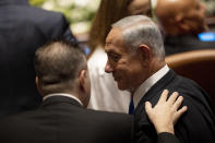 CORRECTS TO SWEARING-IN OF PARLIAMENT, NOT GOVERNMENT - Israel's incoming Prime Minister Benjamin Netanyahu speaks with a colleague at the swearing-in ceremony for Israel's parliament, at the Knesset, in Jerusalem, Tuesday, Nov. 15, 2022. (AP Photo/ Maya Alleruzzo, Pool)