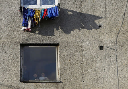 A Roma family look out through the window of a house at the so called "Sheffield Square" in the town of Bystrany, Slovakia, November 28, 2016. Picture taken November 28, 2016. REUTERS/David W Cerny