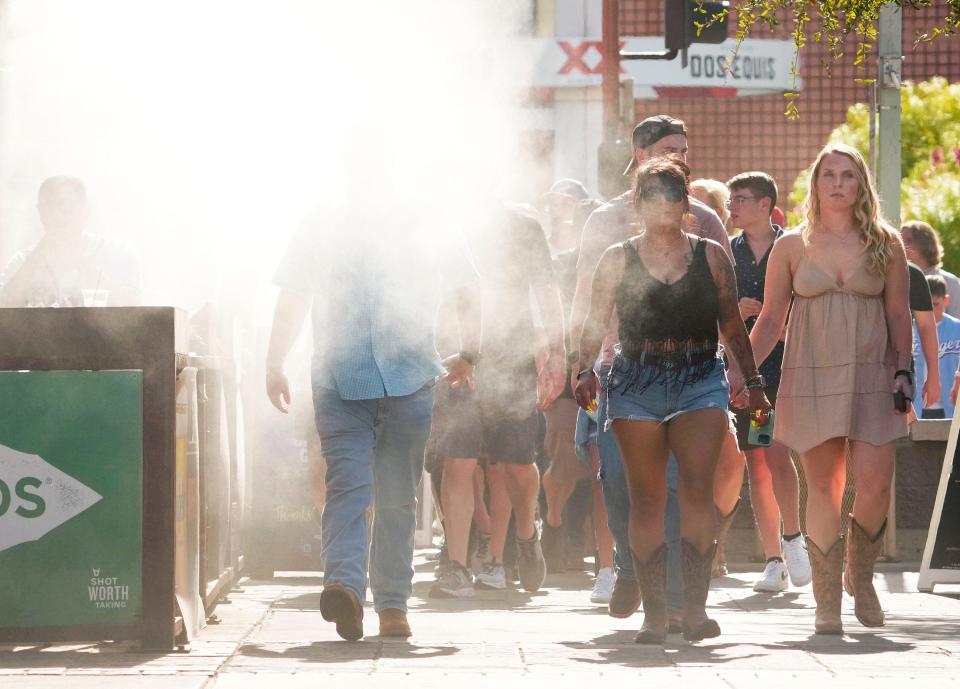 Nozzles spray a mist of water on fans in 119 degree heat arriving for the Morgan Wallen concert at Chase Field in Phoenix on July 19, 2023. Phoenix set three new records on Wednesday, with a low of 97 degrees, a high of 119 degrees, and it was the 20th day in a row of temperatures of 110 degrees or more.