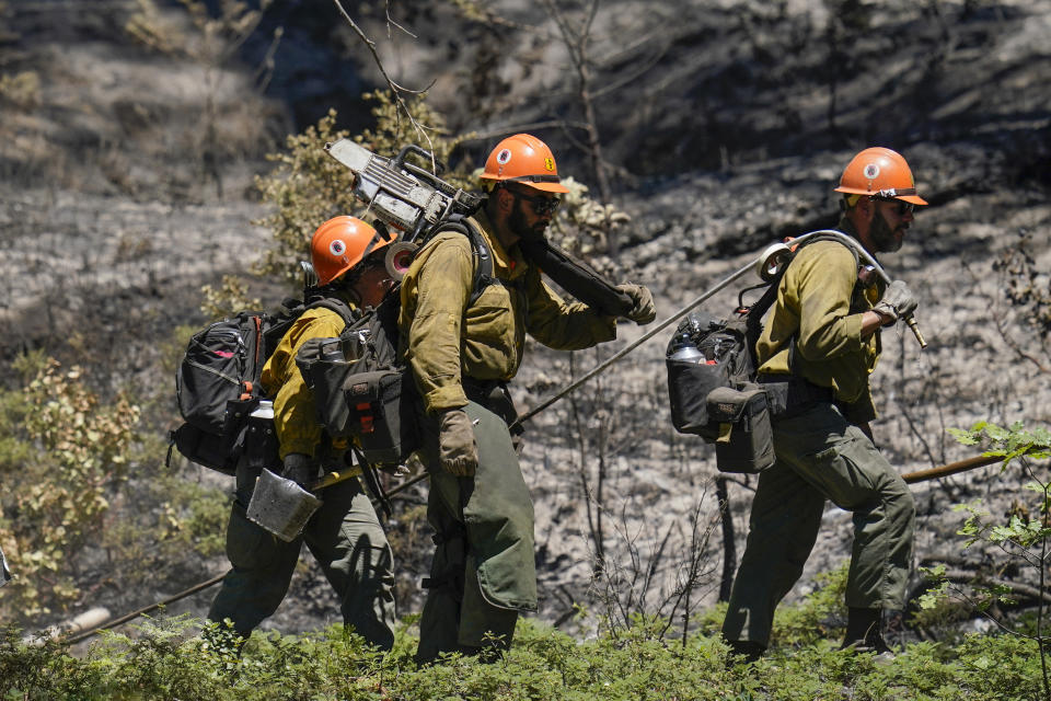 Firefighters move into an area where a back fire took place near the Yosemite National Park south entrance, as the Washburn Fire continues to burn, Tuesday, July 12, 2022, in Calif. (AP Photo/Godofredo A. Vásquez)