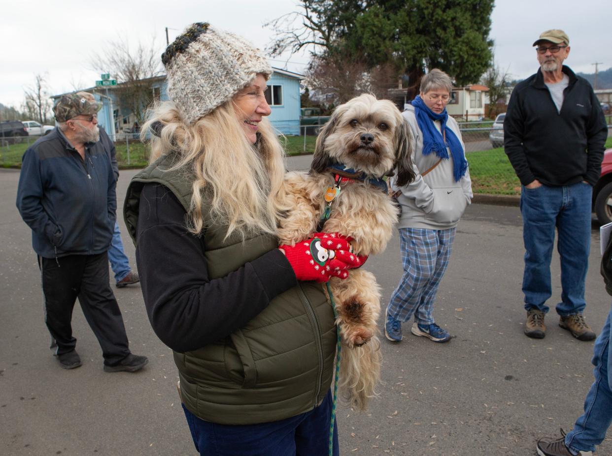 Sherrlyn Bjorkgren, center, with dog Courage, joins a few of her neighbors on a walk around their neighborhood southeast of Eugene near Mt. Pisgah. Many of the people living in the rural trailer park are caught in a land use bind if they wish to upgrade their property.