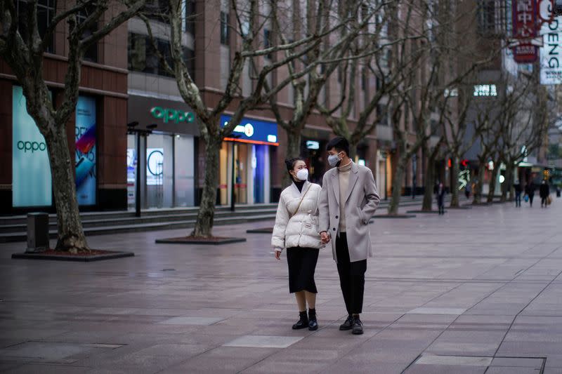 A couple wear masks at a main shopping area, in downtown Shanghai