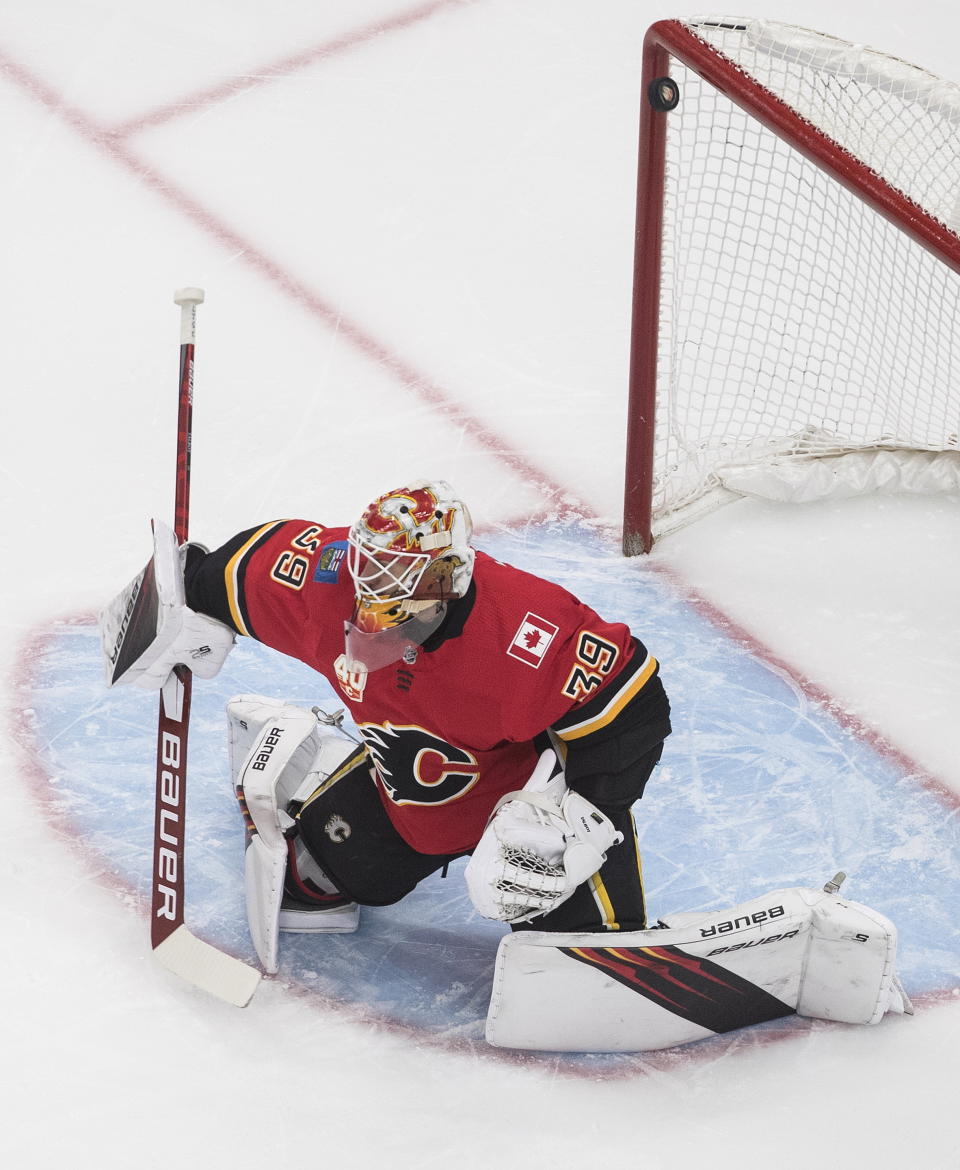 The puck hits the post behind Calgary Flames goalie Cam Talbot (39) on a shot from the Dallas Stars during the first period of an NHL hockey Stanley Cup first-round playoff series, Friday, Aug. 14, 2020, in Edmonton, Alberta. (Jason Franson/The Canadian Press via AP)