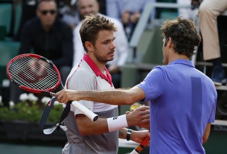 Stan Wawrinka of Switzerland shakes hands with his compatriot Roger Federer after winning their men's quarter-final match during the French Open tennis tournament at the Roland Garros stadium in Paris, France, June 2, 2015. REUTERS/Vincent Kessler