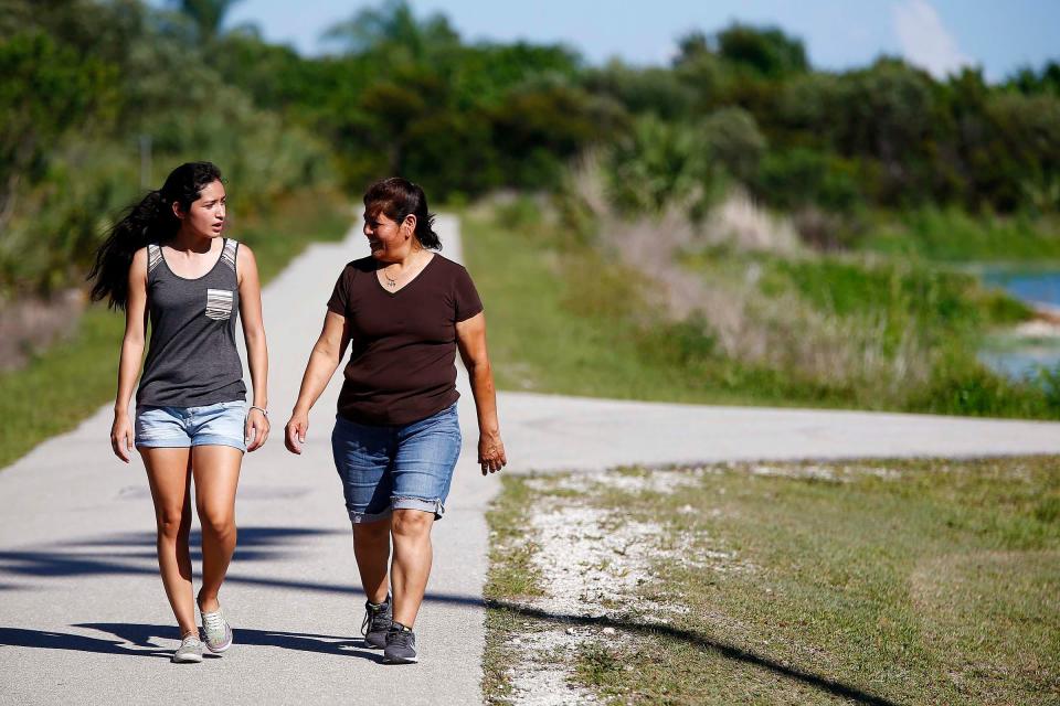 May 7, 2015: Melissa Gomez, 18, left, talks with her mother, Eva Gomez, on a walking trail at Eagle Lakes Park in Naples. Melissa said they walk once a week together. Eva shares a bond with her three daughters, the youngest, 18-year-old daughter, Melissa, is the last one to "leave the nest." Melissa is a journalism major at the University of Florida in Gainesville. The single mother is hard-working who always preached college to her girls. Eva works two jobs, seven days a week and says she takes one vacation a year.