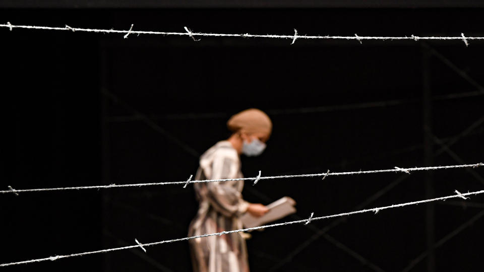 Iolanda Covaci of the Jewish State Theatre performs, wearing a face mask for protection against the COVID-19 infection, during the rehearsals for the premiere of the "The Beautiful Days of My Youth" play, based on the diary of Romanian Jewish Holocaust survivor Ana Novac, in Bucharest, Thursday, Oct. 15, 2020. Friday's debut of "The Beautiful Days of My Youth" by Romanian Jewish Holocaust survivor Ana Novac follows the National Holocaust Remembrance Day commemorations on Oct. 9, the day when deportations of Romania's Jews and Roma began in 1941. (AP Photo/Andreea Alexandru)