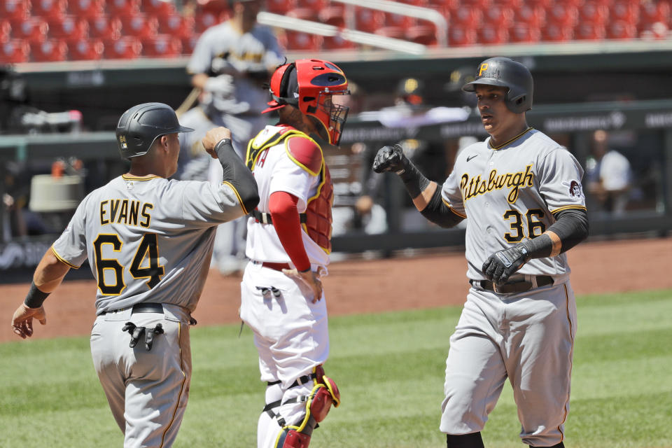 Pittsburgh Pirates' Jose Osuna (36) is congratulated by teammate Phillip Evans (64) after hitting a two-run home run as St. Louis Cardinals catcher Yadier Molina, center, stands at the plate during the fourth inning of a baseball game Sunday, July 26, 2020, in St. Louis. (AP Photo/Jeff Roberson)