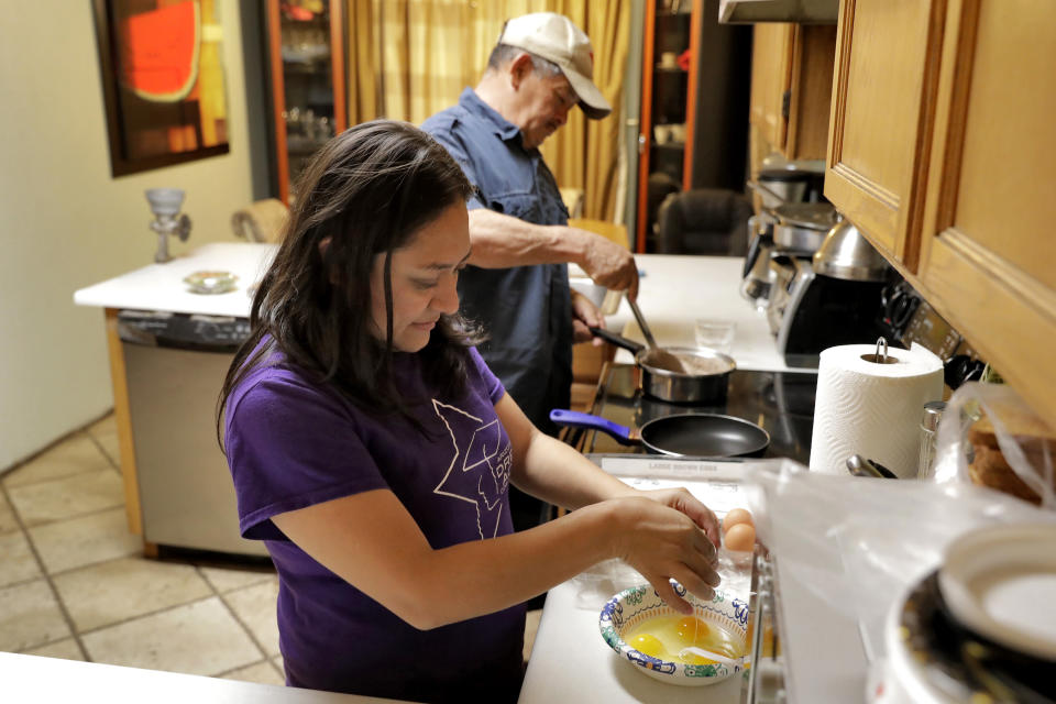 Karina Ruiz and Humberto Diaz prepare dinner at their home, Thursday, Nov. 7, 2019 in Glendale, Ariz. Karina is in a program dating back to the Obama administration that allows immigrants brought here as children to work and protects them from deportation. The U.S. Supreme Court will hear arguments Tuesday, Nov. 12, about President Donald Trump’s attempt to end the program, and the stakes are particularly high for the older generation of people enrolled in Deferred Action for Childhood Arrivals, known as DACA. (AP Photo/Matt York)