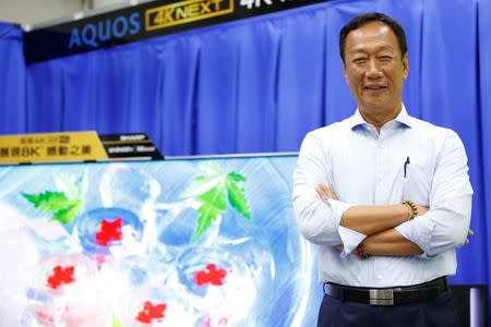 Terry Gou, chairman of Hon Hai Precision Industry, better known as Foxconn, poses for a photo with Sharp Corp's Aquos TV at a Sharp showroom in New Taipei City, Taiwan June 22, 2016. REUTERS/Tyrone Siu