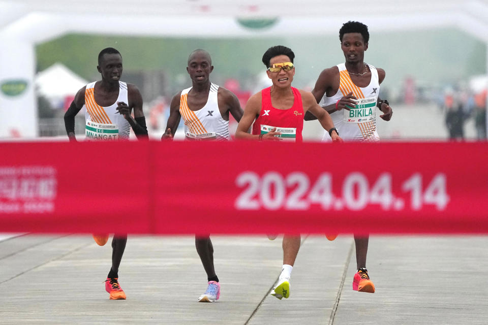 Chinese runner He Jie, Ethiopian Dejene Hailu Bikila and Kenyans Robert Keter and Willy Mnangat take part in a half-marathon in Beijing, China April 14, 2024.  / Credit: China Stringer Network via Reuters