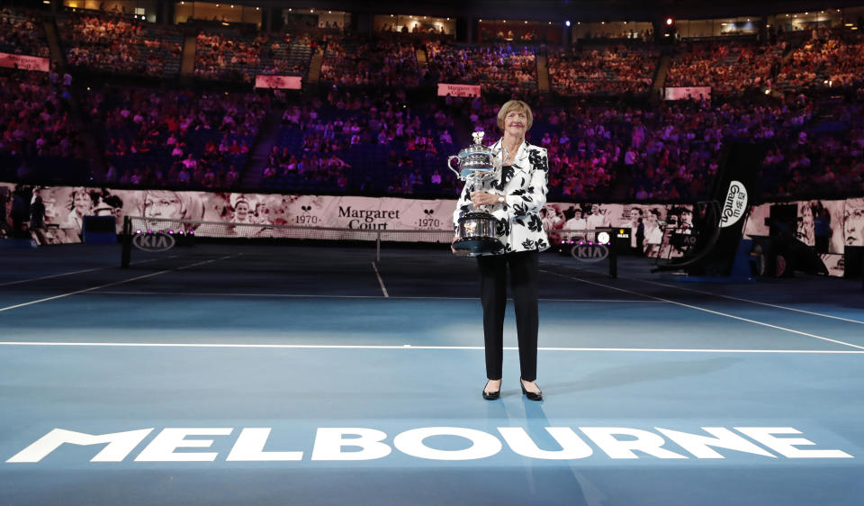 Former Australian Open champion Margaret Court holds up the women's Australian Open trophy, the Daphne Ackhurst Memorial Cup, as her 50th anniversary of her Grand Slam is celebrated at the Australian Open tennis championship in Melbourne, Australia, Monday, Jan. 27, 2020. (AP Photo/Lee Jin-man)