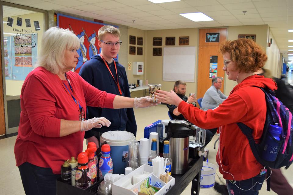 Cassia Oaks (left), an education assistant, and Kaden Kittamus (center), a freshman at Lincoln High School, serve a coffee to Rhonda Lambert, a freshman at Lincoln High School, on May 20, 2022.