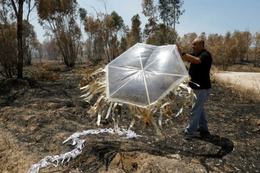 A firefighter from the Jewish National Fund holds a fire kite which was launched across the Gaza border by Palestinian protesters on June 5, 2018 causing damage to scrubland on nearby Kibbutz Beeri