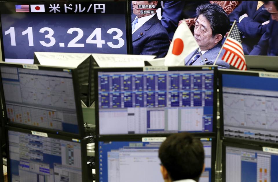 FILE - In this Feb. 1, 2017, file photo, a money trader watches computer screens with the day's exchange rate between Japanese yen and the U.S. dollar as TV shows Japanese Prime Minister Shinzo Abe attending a parliament session at a foreign exchange brokerage in Tokyo. When they meet on Friday, Feb. 10, 2017 in Washington, Abe and U.S. President Donald Trump will be tackling issues where the two sides are unlikely to see eye-to-eye, based on Trump’s recent comments. (AP Photo/Shizuo Kambayashi, File)