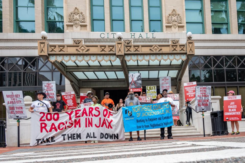 Protestors stand outside Jacksonville City Hall during Saturday's celebration of the Jacksonville's 200th birthday.