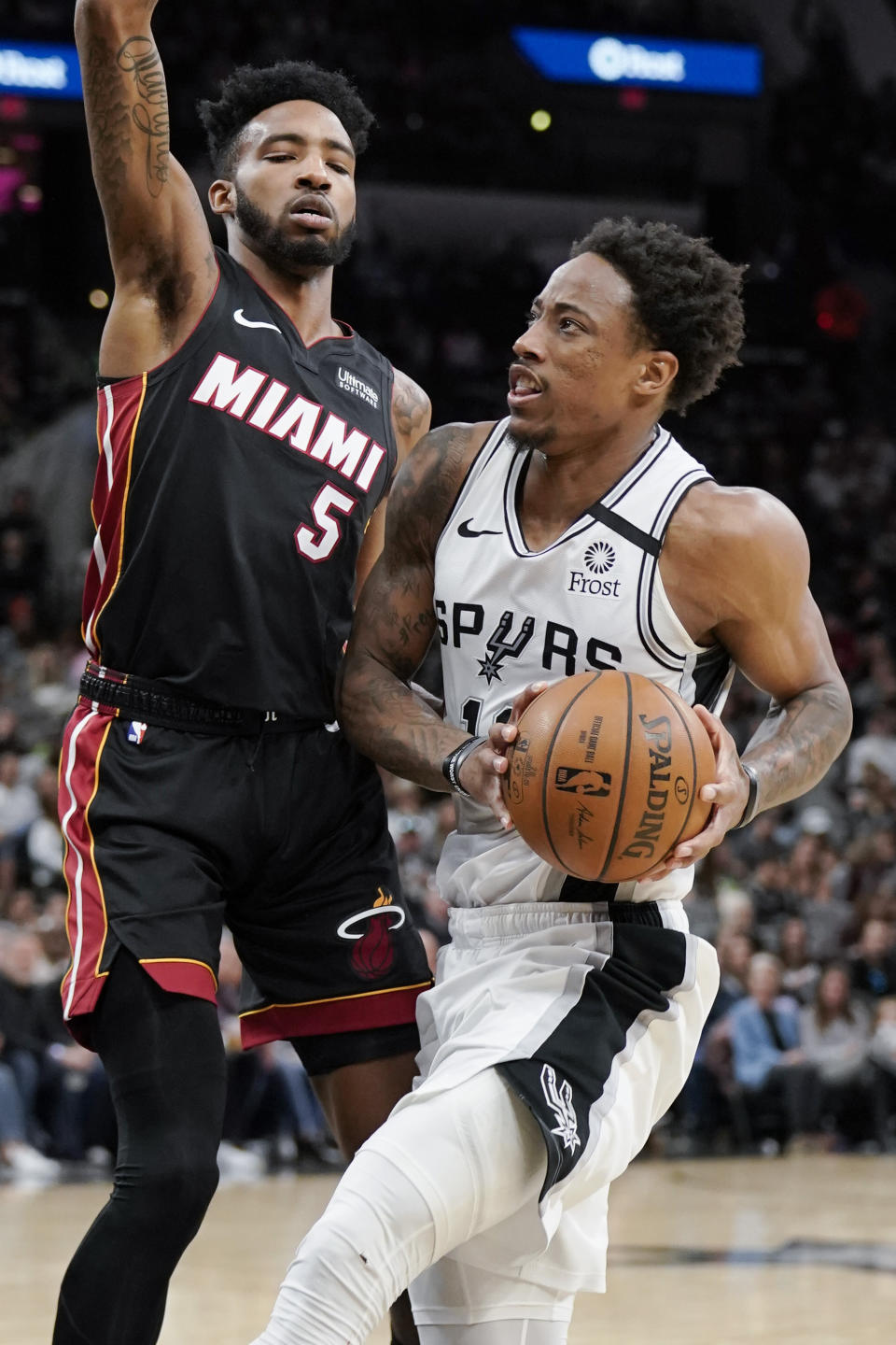 San Antonio Spurs' DeMar DeRozan, right, drives against Miami Heat's Derrick Jones, Jr. during the second half of an NBA basketball game, Sunday, Jan. 19, 2020, in San Antonio. (AP Photo/Darren Abate)