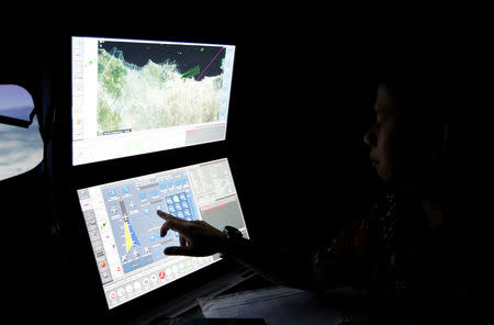 A senior pilot of Lion Air Group points at the control computer as he supervises during a routine practice session on Boeing 737-900ER simulator at Angkasa Training Center near Jakarta, Indonesia, November 2, 2018. REUTERS/Willy Kurniawan