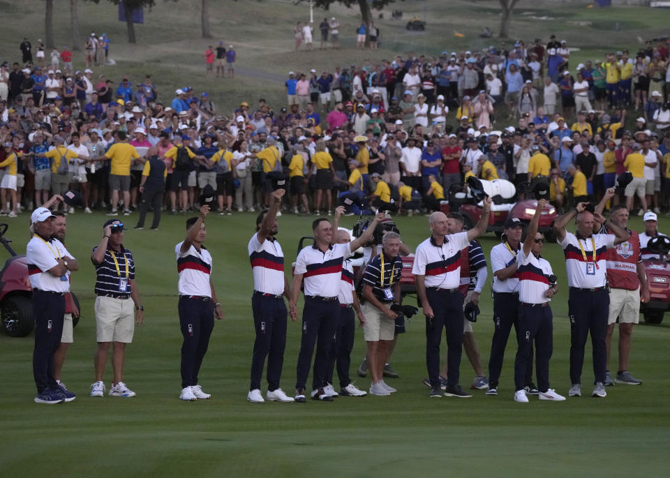 Members off the United States Ryder Cup team cheer United States' Patrick Cantlay after he won his afternoon Fourballs match on the 18th green at the Ryder Cup golf tournament at the Marco Simone Golf Club in Guidonia Montecelio, Italy, Saturday, Sept. 30, 2023. (AP Photo/Alessandra Tarantino)