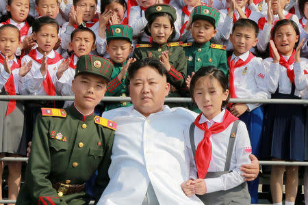 Schoolchildren stand beside North Korean leader Kim Jong Un as he arrives to attend "We Are the Happiest in the World", a performance of schoolchildren to celebrate the 70th founding anniversary of the Korean Children's Union (KCU), in this undated photo released by North Korea's Korean Central News Agency (KCNA) in Pyongyang June 8, 2016. REUTERS/KCNA/File Photo