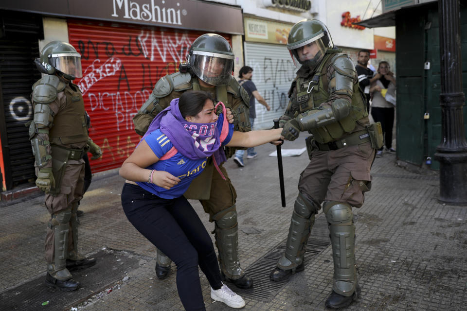 Police grab an anti-government demonstrator in Santiago, Chile, Tuesday, Oct. 29, 2019. Chileans gathered Tuesday for a 12th day of demonstrations that began with youth protests over a subway fare hike and have become a national movement demanding greater socio-economic equality and better public services in a country long seen as an economic success story. (AP Photo/Rodrigo Abd)