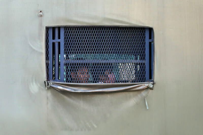 FILE PHOTO: Myanmar migrants to be deported from Malaysia are seen inside an immigration truck, in Lumut