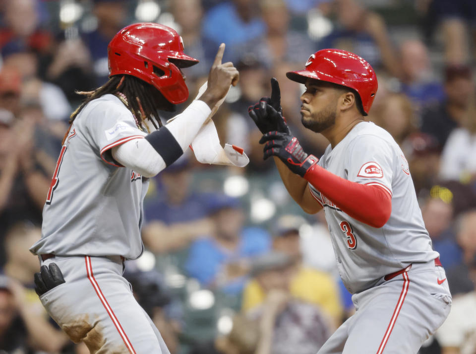 Cincinnati Reds' Elly De La Cruz, left, eacts with Jeimer Candelario, right, after Candelario's two-un home run in the fifth inning of a baseball game against the Milwaukee Brewers, Friday, June 14, 2024, in Milwaukee. (AP Photo/Jeffrey Phelps)