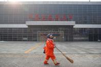 A cleaner walks past the Sihui Long Distance Bus Station in Beijing after the city has stoped inter-province buses services as the country is hit by an outbreak of the new coronavirus