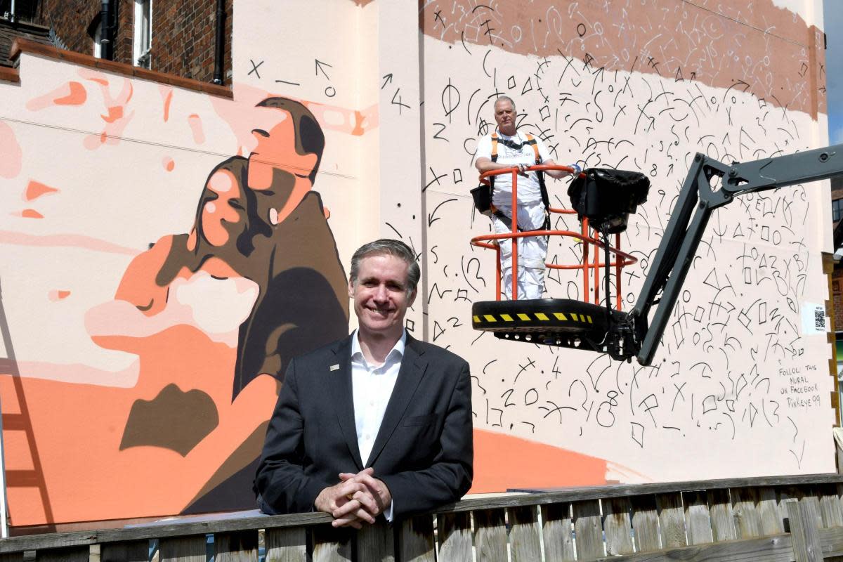 Paul Taylor, chair of the Warrington Arts Council, with artists Pinkeye99 next to the mural <i>(Image: David Gillespie)</i>