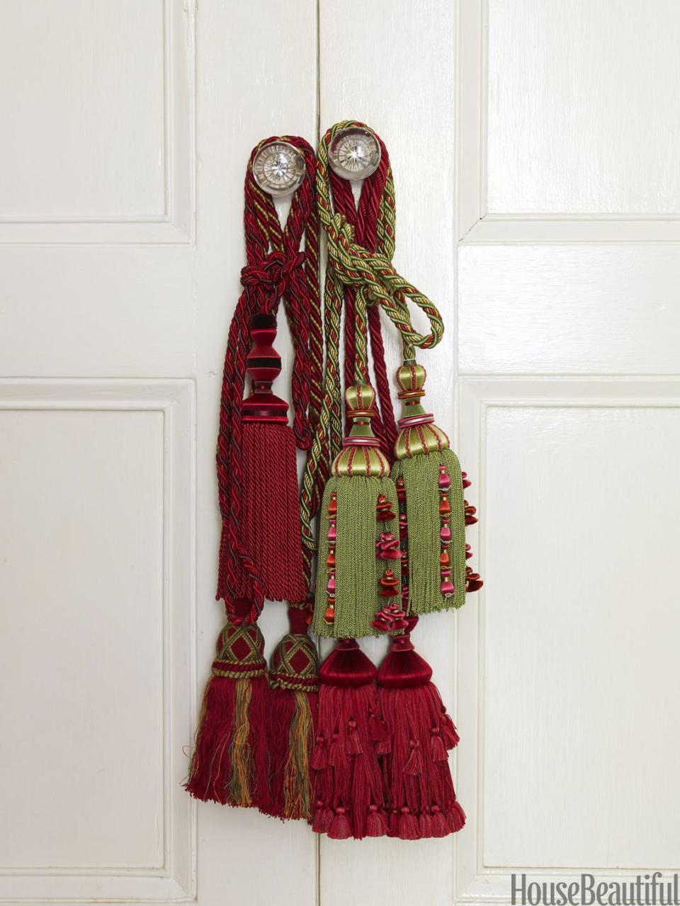 <p>Hang red and green tassels on your doors, desk, and chest of drawers. They're a finishing touch that's totally budget-friendly. </p>