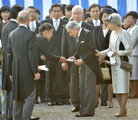 Japanese lawmaker Taro Yamamoto (3rd L) hands a letter to Emperor Akihito (front C), while Empress Michiko (R) looks on, during the annual autumn garden party at the Akasaka Palace imperial garden in Tokyo October 31, 2013. REUTERS/Kazuhiro Nogi/Pool