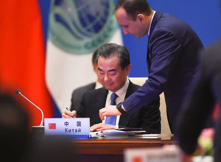 REFILE - CORRECTING IDENTITY Chinese State Councilor and Foreign Minister Wang Yi attends a signing ceremony with foreign ministers and officials of the Shanghai Cooperation Organisation (SCO) at the Diaoyutai State Guest House in Beijing, China, April 24, 2018. Madoka Ikegami/Pool via REUTERS