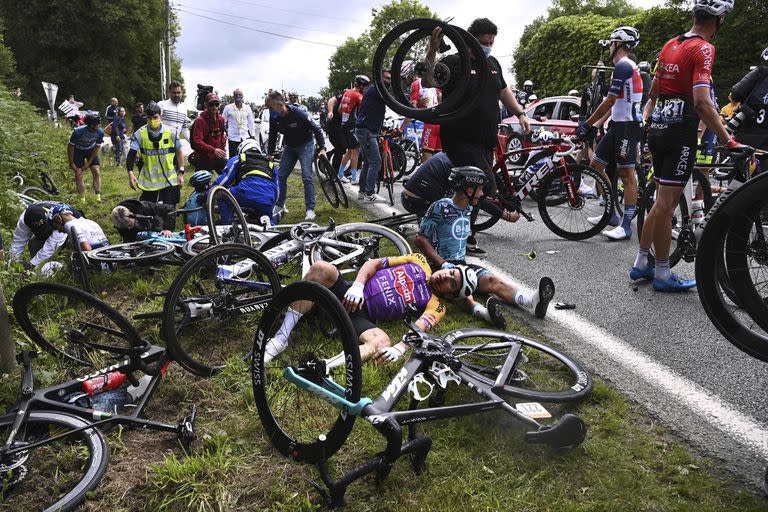 El italiano Kristian Sbaragli (izquierda) y el francés Bryan Coquard (derecha) en el piso tras sufrir una caída en la primera etapa del Tour de Francia, el sábado 26 de junio de 2021. (Anne-Christine Poujoulat, Pool Foto vía AP)