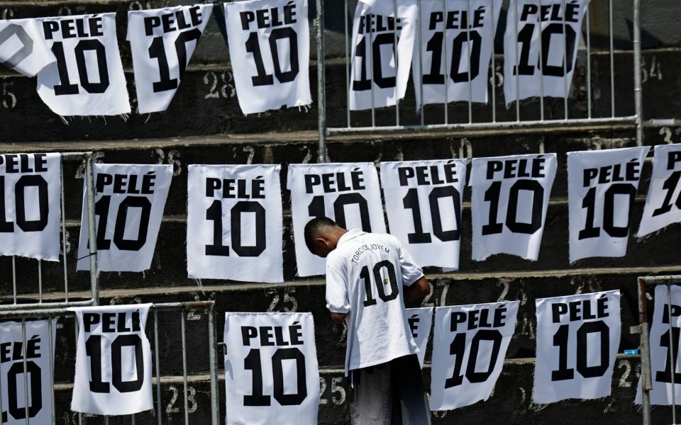 A mourner is pictured inside the stadium of Brazilian soccer legend Pele former club Santos' as he lays in state on the pitch before his funeral - Reuters/Ueslei Marcelino