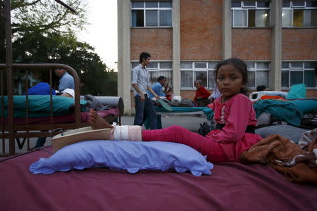 A girl lies on a bed after being moved out from the hospital to the open ground for treatment, in Kathmandu, May 12, 2015. REUTERS/Navesh Chitrakar